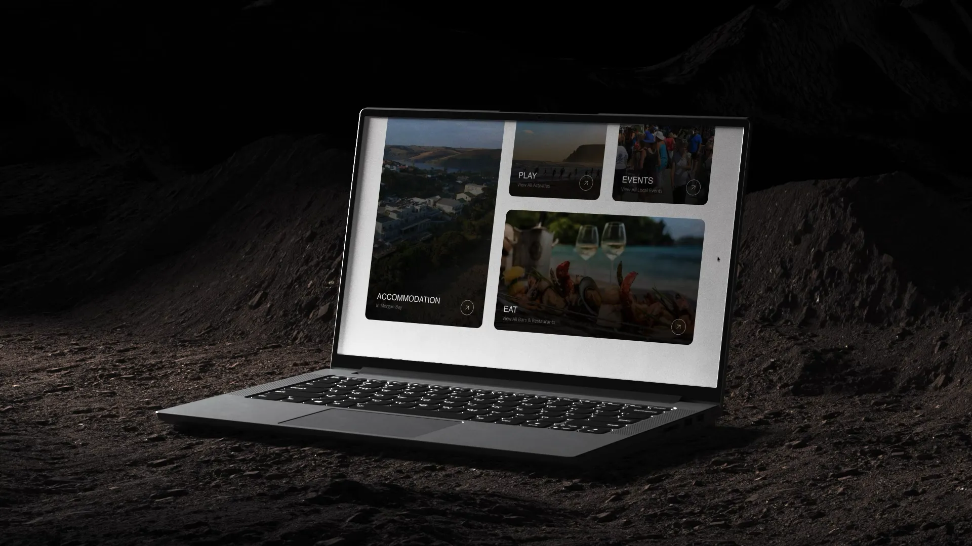 The Morgan Bay Tourism site open on a laptop resting on dark rock