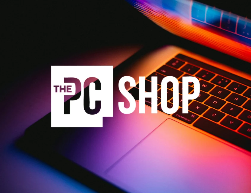 The PC Shop logo over a glowing laptop keyboard